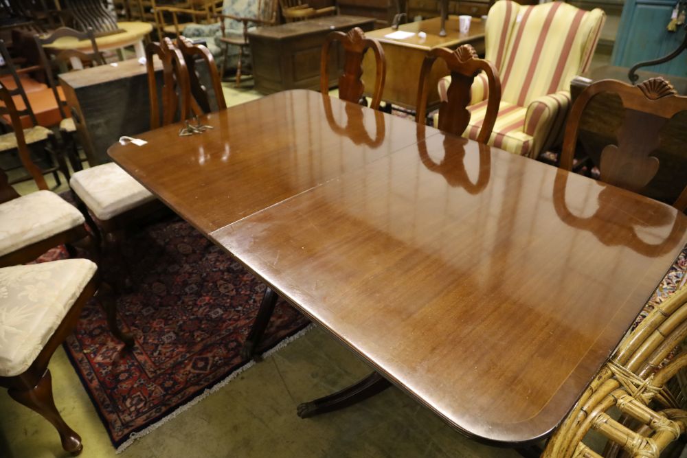 A reproduction mahogany twin pillar extending dining table and eight George I style chairs, 300cm extended (two spare leaves)